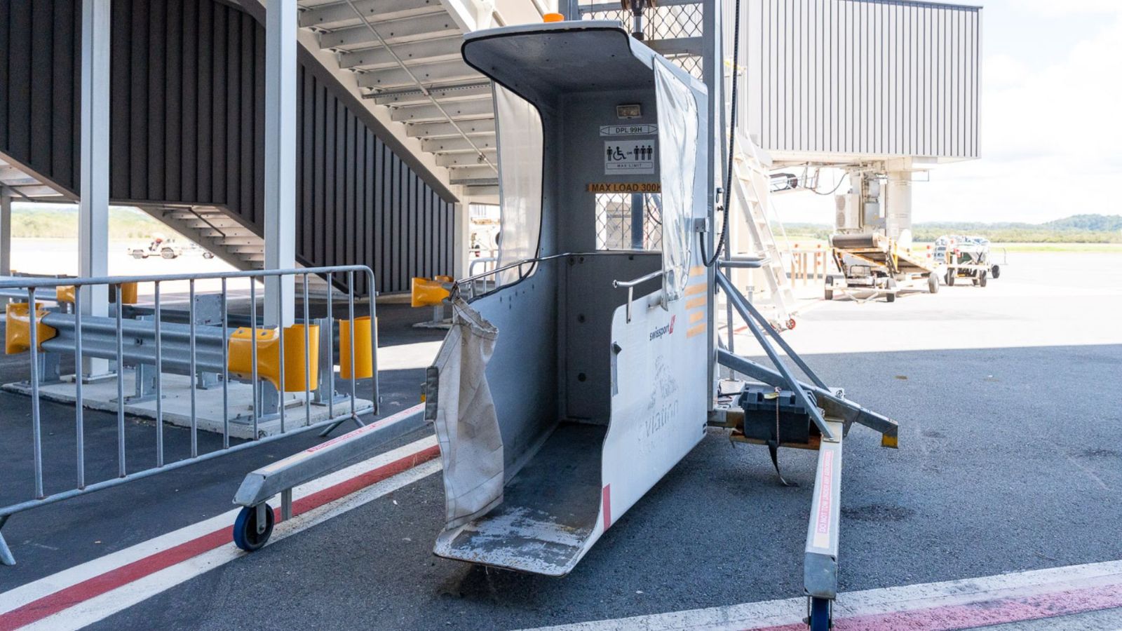 An airport passenger lift positioned on the tarmac, designed to assist travellers with reduced mobility when boarding or disembarking aircraft.