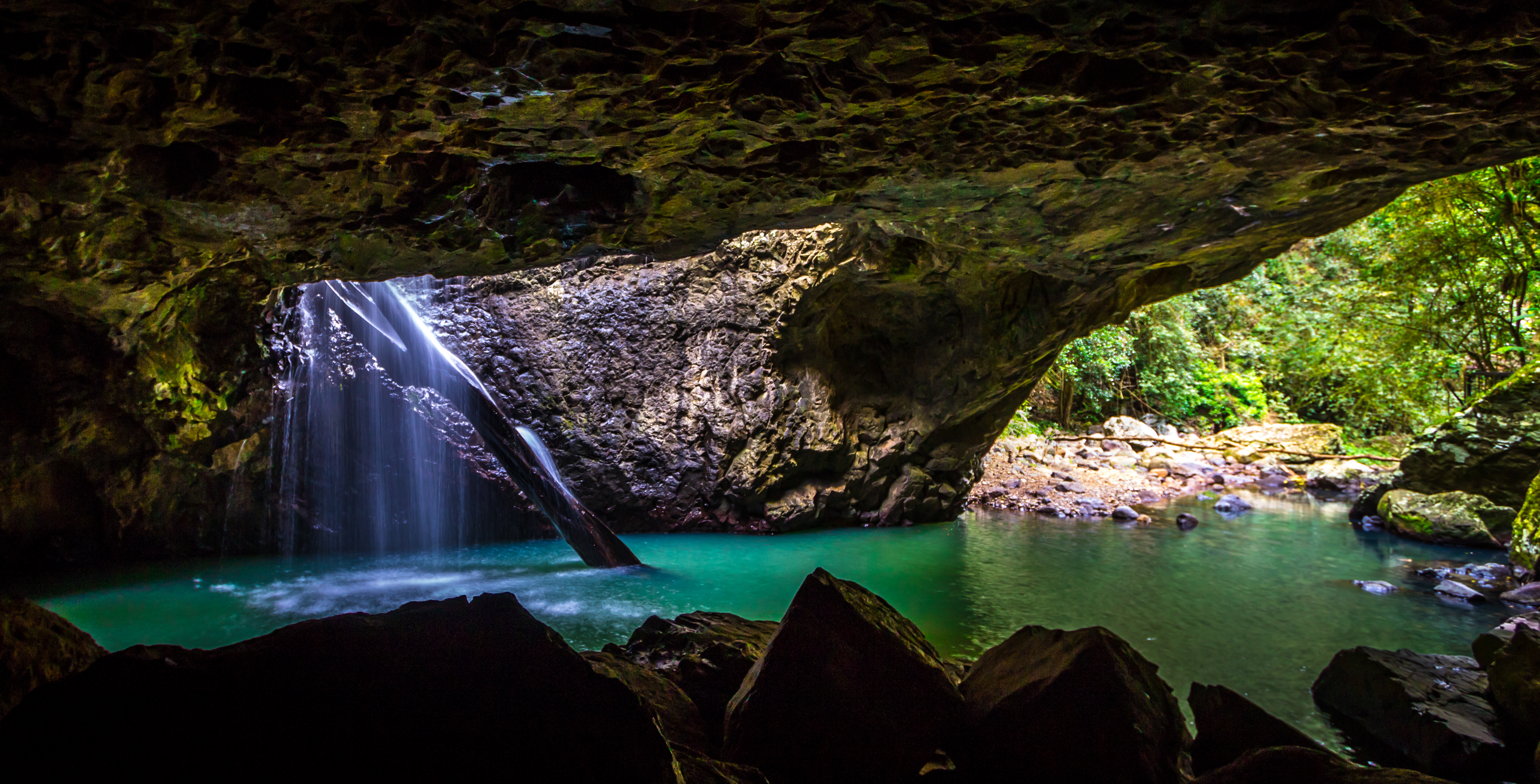 Natural Bridge at Springbrook National Park. Clear blue waters beneath a rocky bridge
